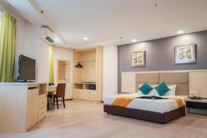 Dormitorio con cama, escritorio y TV en Hotel Sentral Riverview Melaka, en Melaka