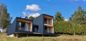 een zwart huis op een heuvel met bomen bij Depandance hotelu Vítkova Hora in Karlsbad