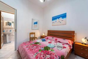 a bedroom with a bed with pink sheets and flowers at Casa Barbara in Nebida
