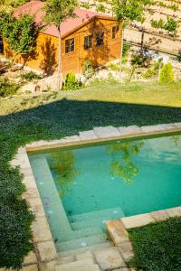 una piscina en un patio con una casa en Masia Cal Magi, en Font-Rubí