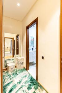 a bathroom with a green rug on the floor and a mirror at Appartement de luxe Prestigia Marrakesch in Marrakesh