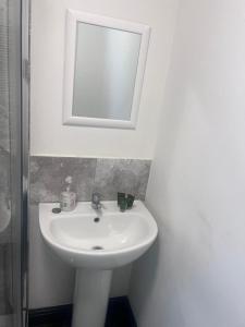 a bathroom with a white sink and a mirror at Mapperley House - UNDER NEW MANAGEMENT PROMOTIONAL RATES AVAILABLE in Nottingham