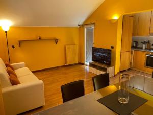 een woonkamer met een witte bank en een tafel bij Attico Paderno Dugnano - Milano in Paderno Dugnano