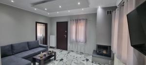 a living room with a couch and a tv at Mimarxos Luxury Apartments in Chalkida