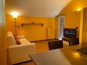 een woonkamer met een witte bank en een televisie bij Attico Paderno Dugnano - Milano in Paderno Dugnano