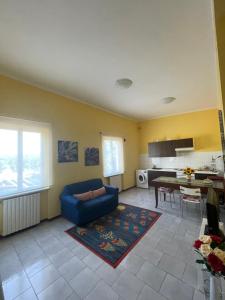 sala de estar con sofá azul y mesa en Alloggio Flaminia con parcheggio di proprietà!, en Bevagna