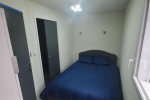 a small bedroom with a blue bed in it at studio indépendant aiton 73 in Aiton