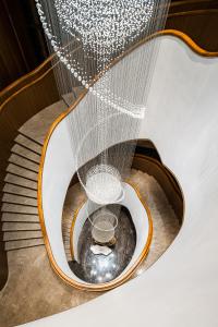 a spiral staircase with a chandelier at Le Méridien Emei Mountain Resort in Emeishan