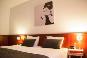 a bedroom with two beds and a painting on the wall at Hotel De Schildkamp in Asperen