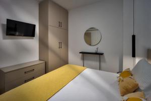 a bedroom with a bed with a yellow blanket at Pap's Lab Apartments in Heraklio