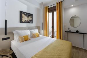 a bedroom with a large bed with yellow curtains at Pap's Lab Apartments in Heraklio