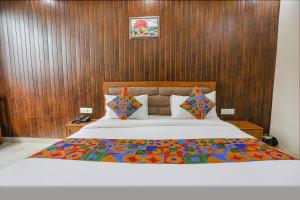 a bedroom with a large bed with wooden walls at FabExpress Premium Luxury Stay in Noida