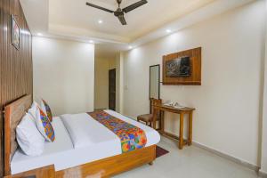 a bedroom with a bed and a desk in it at FabExpress Premium Luxury Stay in Noida
