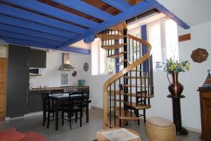 un soggiorno con soffitto blu e scala a chiocciola di DOMAINE DES GRAVIERS a Plainfaing