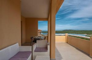 Un balcón con mesa y sillas y vista al mar. en ISA-Residence in Marinella at only 450 m from the beach, apartments with air conditioning, en Marinella