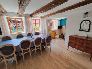 uma sala de jantar com uma mesa azul e cadeiras em Maison au cœur des vignobles em Westhoffen