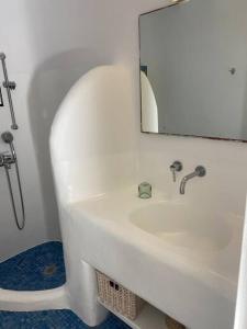 a bathroom with a white sink and a mirror at AGRARI VILLAGE Pool Residence in Agrari