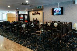 a waiting room with chairs and a tv on the wall at Hotel Sentral Riverview Melaka in Melaka