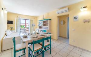 Una cocina y un comedor con mesa y sillas. en ISA-Residence in Marinella at only 450 m from the beach, apartments with air conditioning, en Marinella 30 fotos más