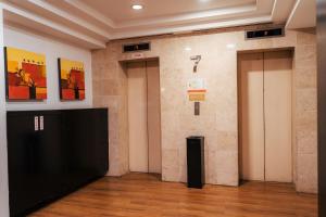 a room with two elevators and a wall at Hotel Sentral Riverview Melaka in Melaka