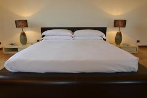 マテーラにあるAntica Civita B&B Luxury Roomの大きな白いベッド(2つのテーブルにランプ2つ付)