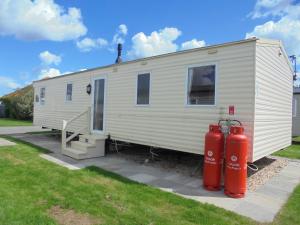 a white trailer with two red fire hydrants in front of it at Kingfisher : Horizon II:- 8 Berth, Close to site entrance in Ingoldmells