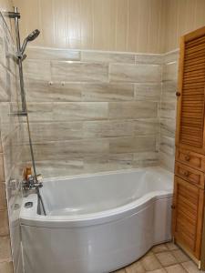 a white bath tub sitting in a bathroom at Maison les pieds dans l'eau in Quinéville