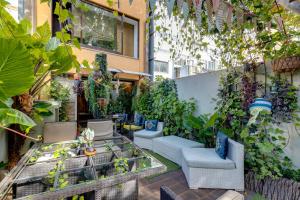 an outdoor patio with chairs and plants on a building at Garden in Town Hostel in Porto