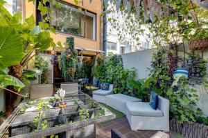 zewnętrzne patio z krzesłami i roślinami w budynku w obiekcie Garden in Town Hostel w Porto
