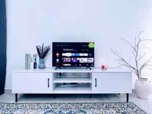 um centro de entretenimento branco com uma televisão de ecrã plano em LT Home em Sandakan
