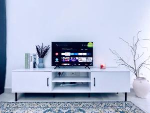 a white entertainment center with a flat screen tv on it at LT Home 1 in Sandakan