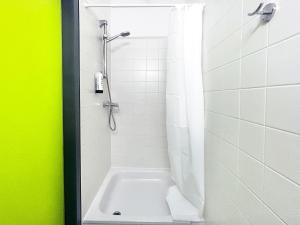a bathroom with a shower with a white tub at Hotel Astral Vienna in Vienna
