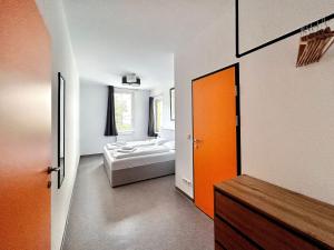 a bedroom with an orange door and a bed at Hotel Astral Vienna in Vienna