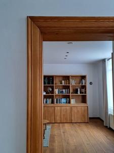 a room with a book shelf and a wooden door at Maison Patisson in Kasterlee