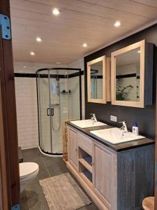 a bathroom with a shower and two sinks and a toilet at Maison Patisson in Kasterlee