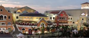 a shopping center with many buildings and palm trees at Albatros Apartments in Guayaquil