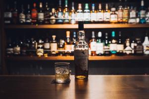 箱根的住宿－root hakone，一瓶威士忌和一张桌子上的一杯