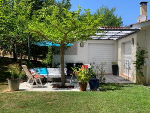 a patio with a table and a tree in a yard at La Maison d’Isabel in Montauban