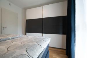 Stilvolle 2-Zimmer Wohnung in Graz-Lend في غراتس: سريرين في غرفة باللونين الأسود والأبيض