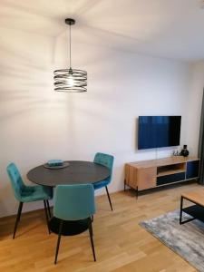 Stilvolle 2-Zimmer Wohnung in Graz-Lend في غراتس: غرفة طعام مع طاولة وكراسي وتلفزيون