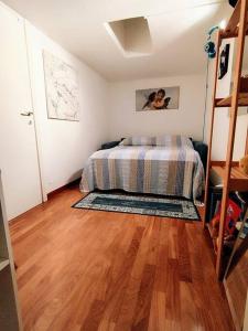 a bedroom with a bed and a wooden floor at I love Pesaro in Pesaro