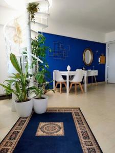 a room with a table and plants and a blue wall at I love Pesaro in Pesaro