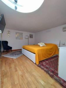 a bedroom with a bed with an orange blanket at I love Pesaro in Pesaro