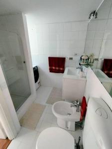a white bathroom with a toilet and a sink at I love Pesaro in Pesaro