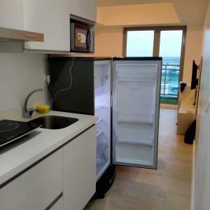eine Küche mit Kühlschrank und Spüle in der Unterkunft Azure north pampangga BALI in Maimpis