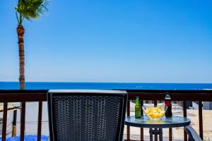 a table with a drink on a balcony with the beach at Penthouse Ocean View Puerto del Carmen in Puerto del Carmen