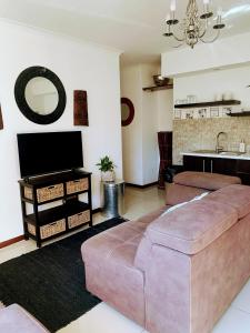 sala de estar con sofá y TV en Regent Casa’s, en Ciudad del Cabo