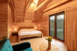 a bedroom in a log cabin with a bed at Chalet Martuška - Drevenica so saunou - Celá dolina len pre vás in Levoča