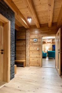 einen Flur mit Holzwänden, Holzböden und einer Tür in der Unterkunft CHALET Martuška in Levoča