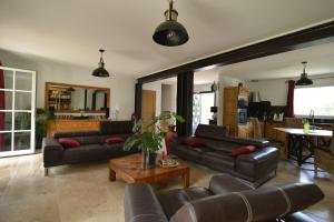 a living room with couches and a table at La Lézarde, chambre d'hôte, piscine, salle d'eau privatif, café ou thé offert le matin in Saint-Victor-la-Coste
